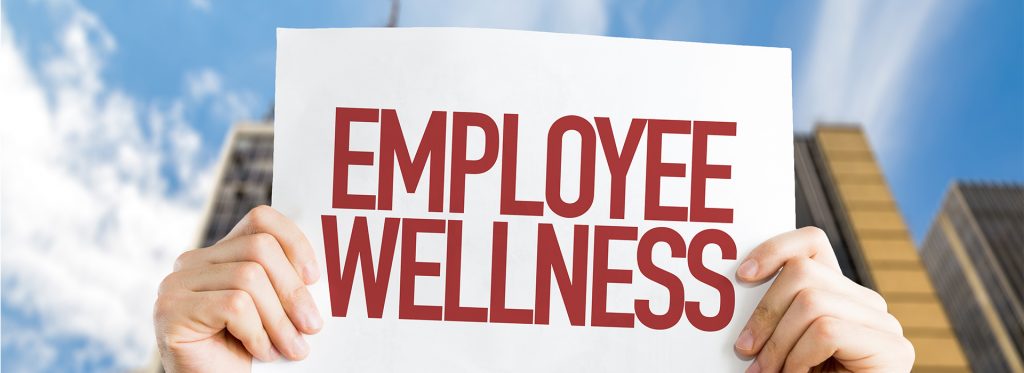 hands holding up sign that reads Employee Wellness
